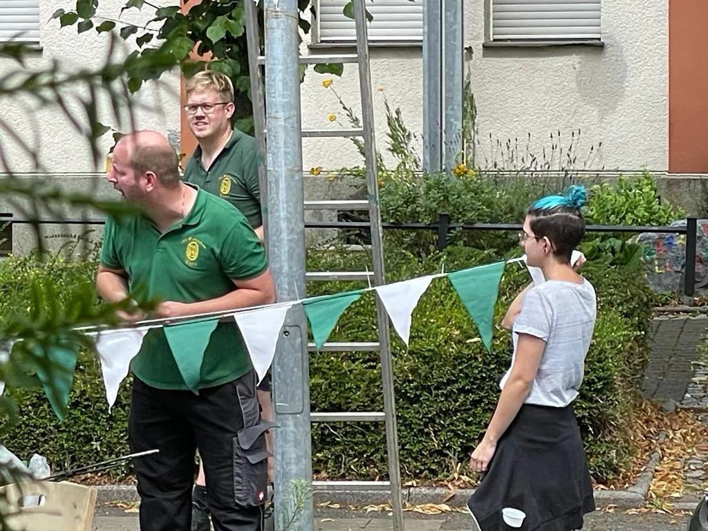 Vereinsmitglieder beim Auflegen der Wimpel zwischen Laternenmasten