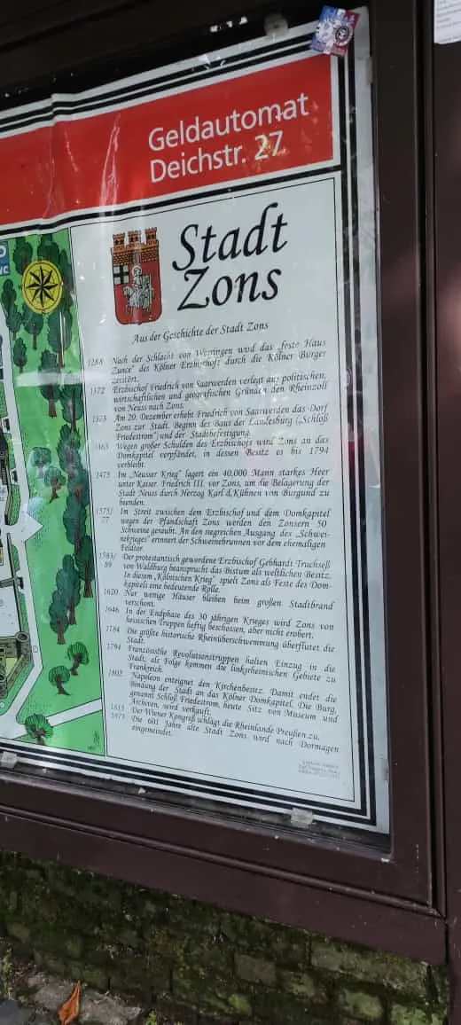 Informationstafel mit der Stadtgeschichte von Zons an einer Hauswand