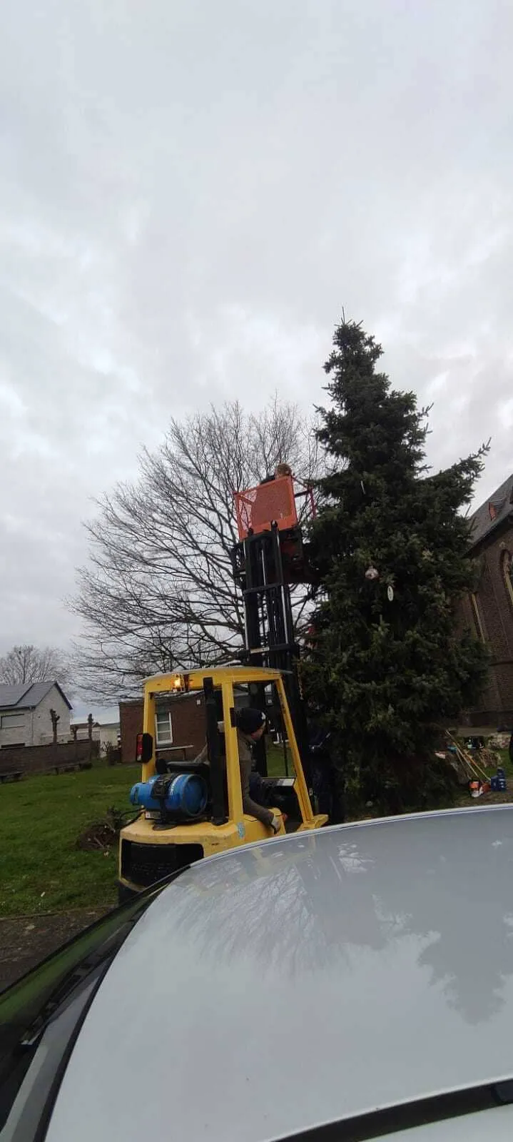 Gabelstapler-Arbeitsbühne neben der Kirche beim Abbau des Weihnachtsbaums