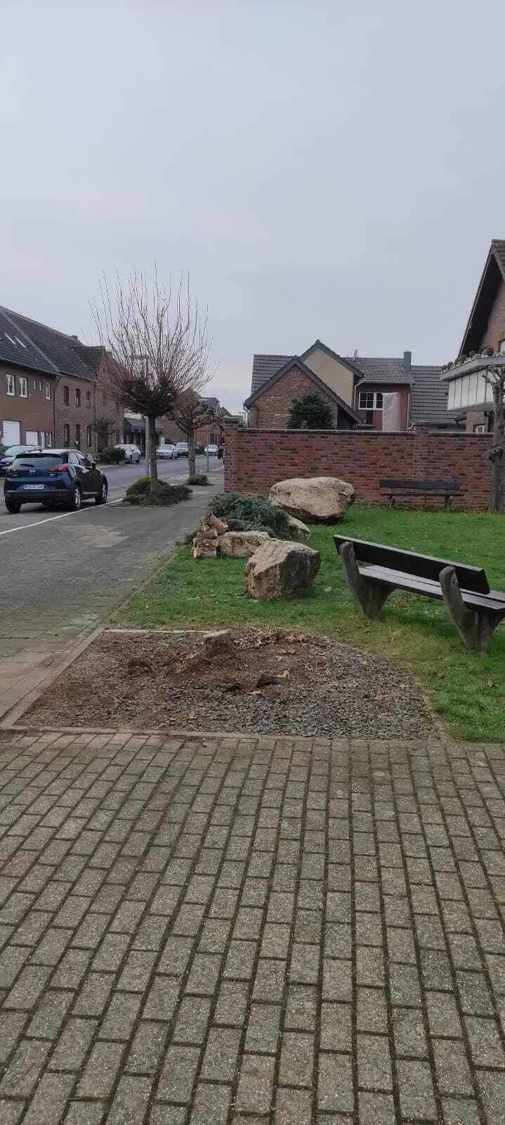 Geräumte Stellfläche neben Sitzbänken am Dorfplatz – Vorbereitung für das neue Schild