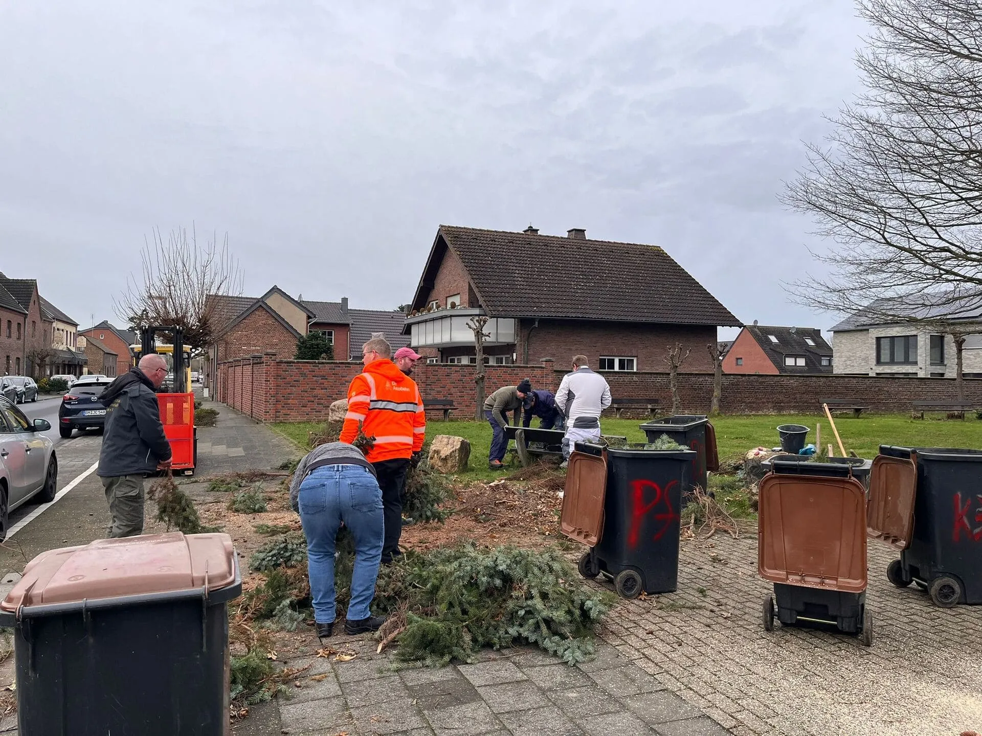 Helfer beim gemeinsamen Wegräumen der Tannenzweige nach dem Weihnachtsbaum-Abbau