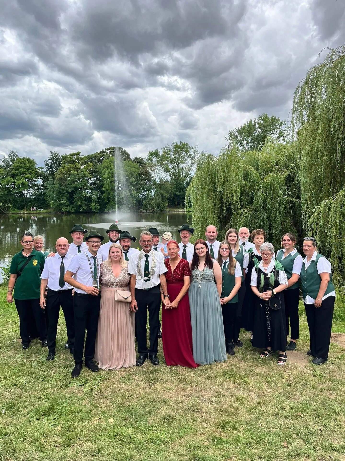 Gruppenbild der Bruderschaft in Festkleidung vor einer Fontäne im Park