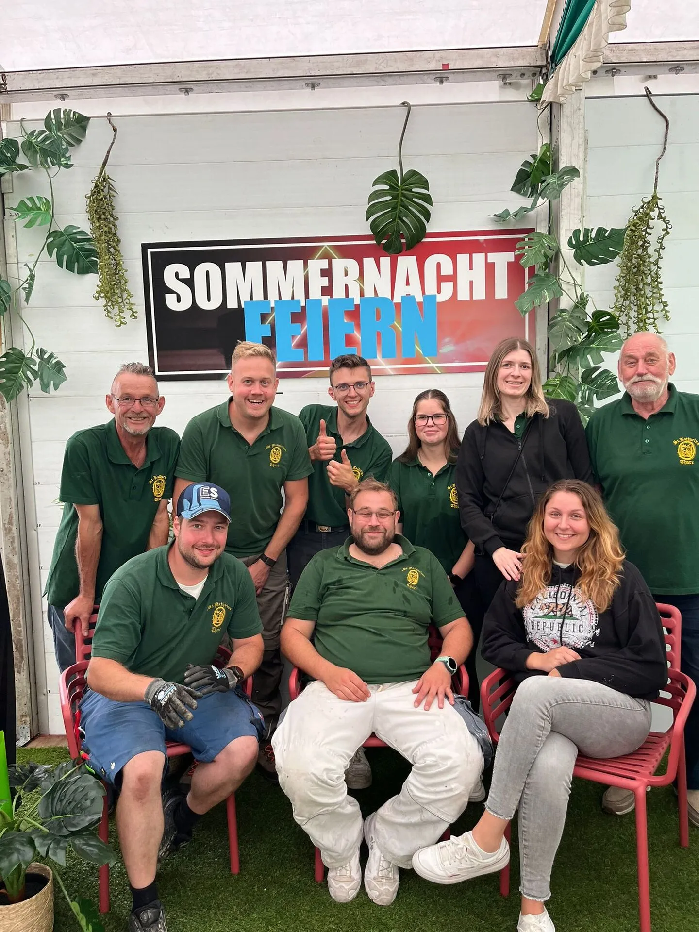 Gruppenbild von neun Helfern auf dem Foto-Set vor dem „SOMMERNACHT FEIERN"-Banner